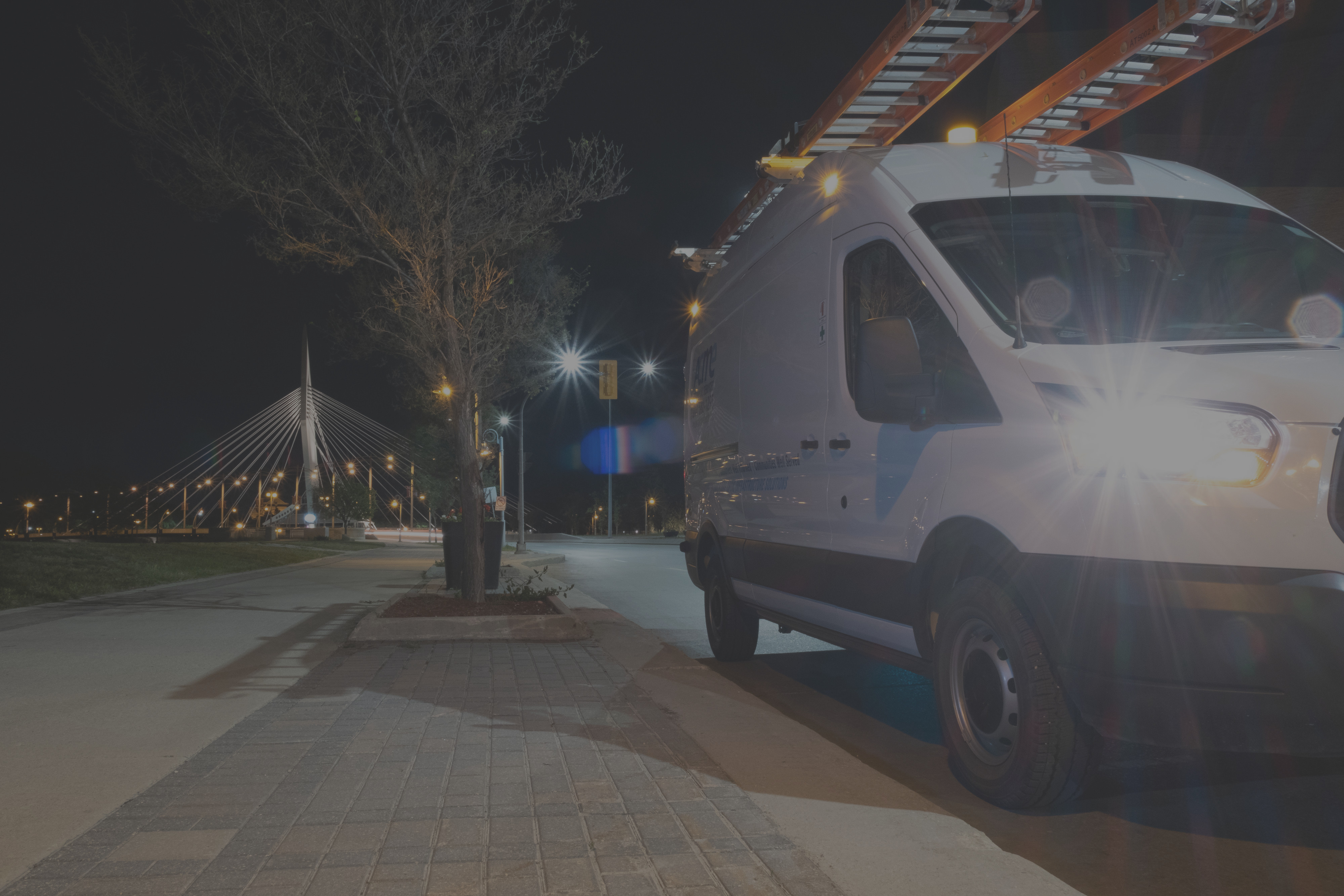 Background image of an ACME van parked by the Provencher Bridge in Winnipeg.